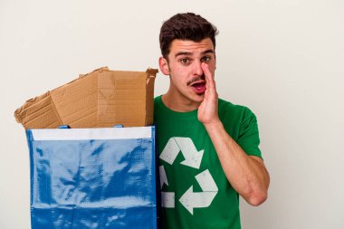 Beyaz arka planda izole edilmiş karton geri dönüşümü yapan beyaz bir adam.