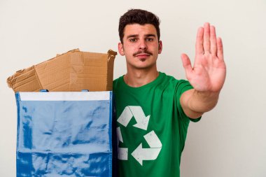 Beyaz arka planda izole edilmiş karton geri dönüşümü yapan beyaz bir adam.