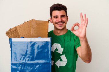 Beyaz arka planda izole edilmiş karton geri dönüşümü yapan beyaz bir adam.