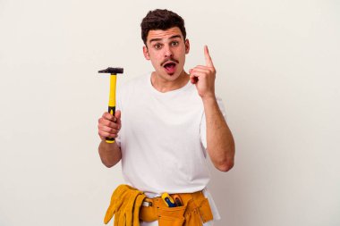 Beyaz arka planda izole edilmiş aletleri olan genç beyaz işçi bir fikri, ilham konsepti var..