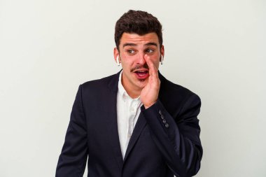 Beyaz arka planda izole edilmiş kablosuz kulaklık takan genç beyaz iş adamı gizli bir fren haberinin olduğunu söylüyor.