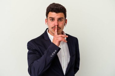 Beyaz arka planda izole edilmiş kablosuz kulaklık takan genç beyaz iş adamı ya sır saklıyor ya da sessizlik istiyor..