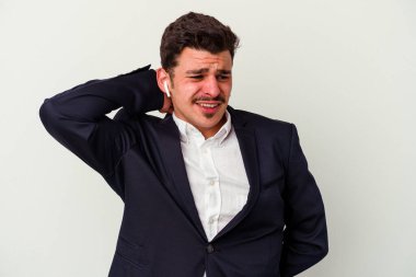 Beyaz arka planda izole edilmiş kablosuz kulaklık takan beyaz iş adamı kafasının arkasına dokunuyor, düşünüyor ve bir seçim yapıyor..