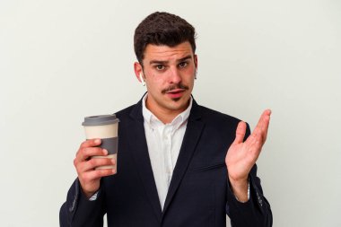 Kablosuz kulaklık takan ve elinde tuttuğu beyaz arka planda izole edilmiş kahve alan beyaz iş adamı şaşırdı ve şok oldu..