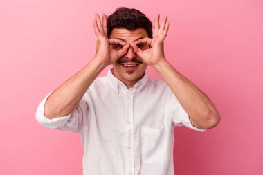 Pembe arka planda izole edilmiş genç beyaz adam gözlerinde sorun olmadığını gösteriyor.