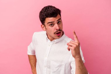 Pembe arka planda soyutlanmış genç beyaz bir adamın bir fikri var, ilham verici bir kavram..