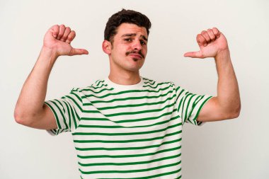 Beyaz arka planda izole edilmiş genç beyaz adam gururlu ve kendinden emin hissediyor, örnek olarak..