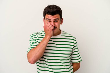 Beyaz arka planda izole edilmiş, tırnak yiyen, gergin ve endişeli genç bir beyaz adam..