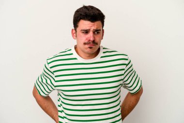 Beyaz arka planda soyutlanmış genç beyaz bir adam kafası karışmış, şüpheli ve güvensiz hissediyor..