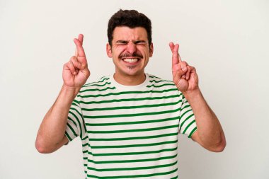 Beyaz arka planda izole genç beyaz adam şans dilemek için şans diliyor.