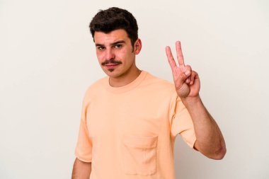 Beyaz arka planda izole edilmiş genç beyaz bir adam neşeli ve kaygısız parmakları olan bir barış sembolü gösteriyor..