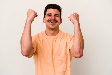 Beyaz arka planda izole edilmiş genç beyaz adam tasasız ve heyecanlı bir şekilde tezahürat yapıyor. Zafer konsepti.