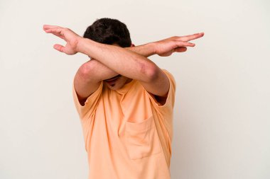 Beyaz arka planda izole genç beyaz adam iki kolu çapraz tutuyor, inkar kavramı.