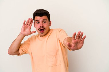 Beyaz arka planda izole genç beyaz adam yakın bir tehlike nedeniyle şoka uğruyor