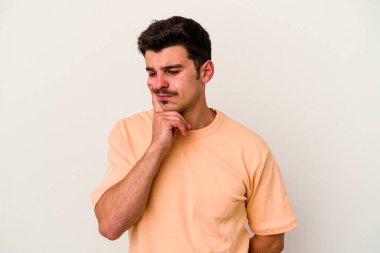 Beyaz arka planda izole edilmiş genç beyaz bir adam bir strateji planlıyor, bir iş yolu düşünüyor..