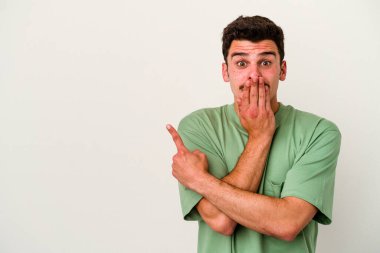Beyaz arka planda izole edilmiş genç beyaz adam yan tarafı işaret ediyor