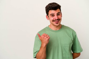 Beyaz arka planda izole edilmiş genç beyaz bir adam işaret parmağıyla fotokopi alanını işaret ederek şok oldu..