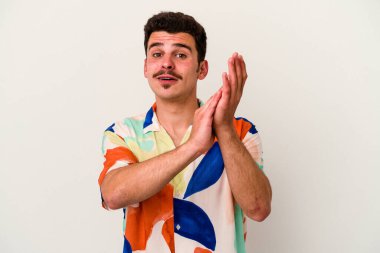 Beyaz arka planda izole olmuş genç beyaz bir adam enerjik ve rahat hissediyor, ellerini ovuşturuyor..