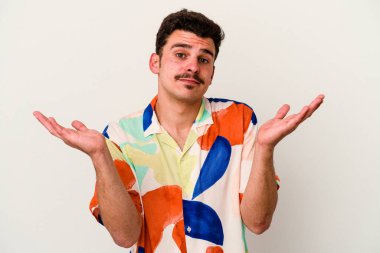 Beyaz arka planda izole edilmiş genç beyaz bir adam. Kafası karışmış ve omuz silkiyor. Kopya alanını tutmak için..