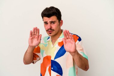 Beyaz arka planda izole edilmiş genç beyaz bir adam tiksinti belirtisi gösteren birini reddediyor..