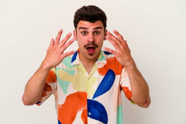 Beyaz arka planda izole edilmiş beyaz tenli genç adam on numarayı elleriyle gösteriyor..