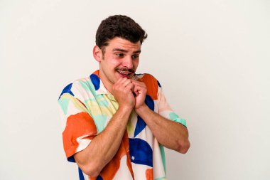 Beyaz arka planda izole genç beyaz adam ellerini çenesinin altında tutuyor, mutlu bir şekilde yana bakıyor..