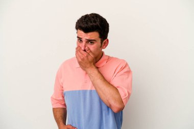 Beyaz arka planda izole edilmiş genç beyaz bir adam ağzı kapalı ve elleri endişeli görünüyor..