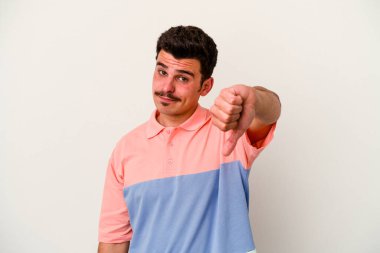 Beyaz arka planda izole edilmiş genç beyaz adam baş parmağını aşağı gösteriyor, hayal kırıklığı konsepti..