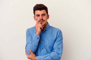 Beyaz arka planda izole edilmiş genç beyaz bir adam bir strateji planlıyor, bir iş yolu düşünüyor..