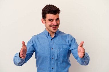 Beyaz arka planda izole edilmiş beyaz bir adam iki eliyle bir şey tutuyor..