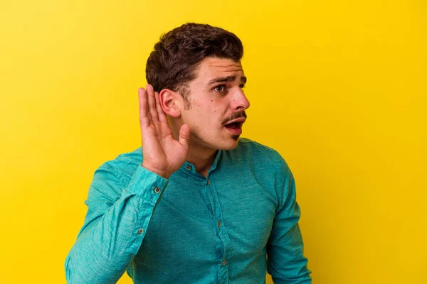 Mladý Kavkazský Muž Izolovaný Žlutém Pozadí Snaží Poslouchat Klepy — Stock fotografie