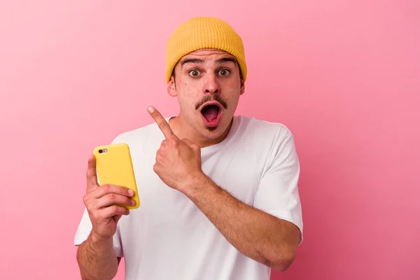 Joven Hombre Caucásico Sosteniendo Teléfono Móvil Aislado Sobre Fondo Rosa —  Fotos de Stock