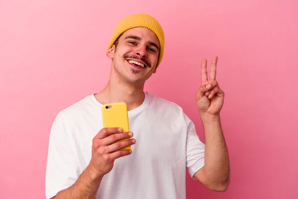 Młody Biały Mężczyzna Trzymając Telefon Komórkowy Odizolowany Różowym Tle Radosny — Zdjęcie stockowe