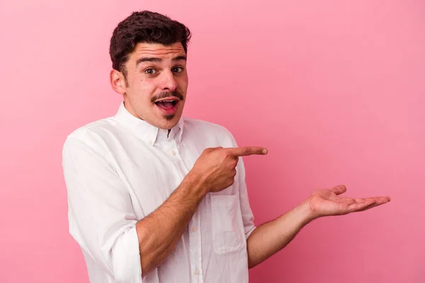 Young Caucasian Man Isolated Pink Background Excited Holding Copy Space — Stock Photo, Image