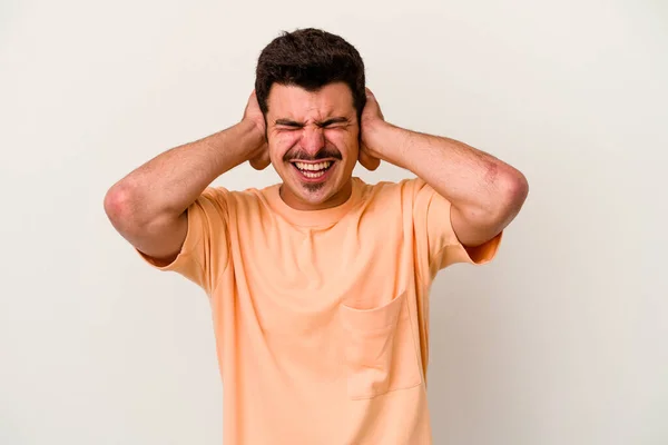 Mladý Běloch Izolovaný Bílém Pozadí Zakrývající Uši Rukama Snažící Neslyšet — Stock fotografie