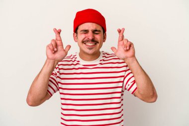 Beyaz arka planda izole genç beyaz adam şans dilemek için şans diliyor.