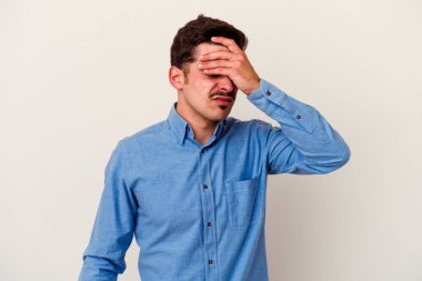 Beyaz arka planda izole edilmiş genç beyaz bir adam tapınaklara dokunuyor ve başı ağrıyor..