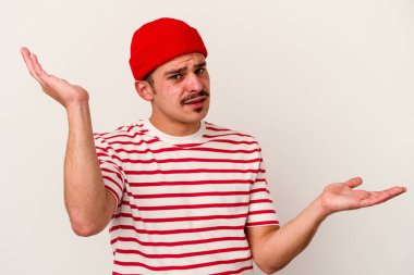 Beyaz arka planda izole edilmiş genç beyaz bir adam. Kafası karışmış ve omuz silkiyor. Kopya alanını tutmak için..