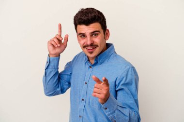 Beyaz arka planda izole edilmiş genç beyaz bir adam farklı kopya alanlarını gösteriyor, birini seçiyor, parmaklarıyla gösteriyor..