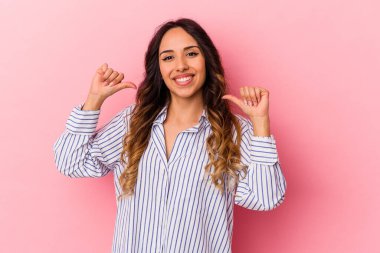 Pembe arka planda izole edilmiş genç Meksikalı kadın kendini gururlu ve kendinden emin hissediyor..