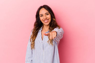Pembe arka planda izole edilmiş genç Meksikalı kadın gülümsüyor..