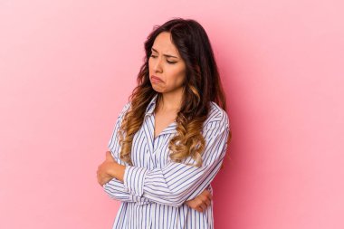 Pembe arka planda izole edilmiş genç Meksikalı kadın tekrarlanan bir görevden yoruldu..