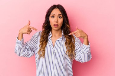 Pembe arka planda izole edilmiş genç Meksikalı kadın parmakları aşağıda, olumlu bir his..