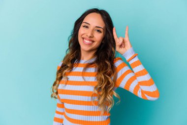 Mavi arka planda izole edilmiş genç Meksikalı kadın boynuzlarını devrim konsepti olarak gösteriyor..