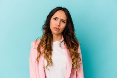 Genç Meksikalı kadın mavi arka planda izole edilmiş üzgün, ciddi yüzlü, mutsuz ve hoşnutsuz..