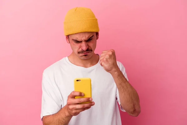 Joven Hombre Caucásico Sosteniendo Teléfono Móvil Aislado Sobre Fondo Rosa —  Fotos de Stock