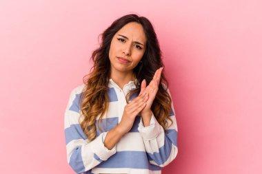 Pembe arka planda izole edilmiş genç Meksikalı kadın enerjik ve rahat hissediyor, ellerini ovuşturuyor..