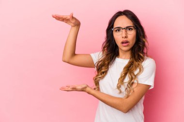 Pembe arka planda izole edilmiş genç Meksikalı kadın elleri arasında bir fotokopi alanı tutuyor..