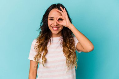 Mavi arka planda izole edilmiş genç Meksikalı kadın heyecanlı..