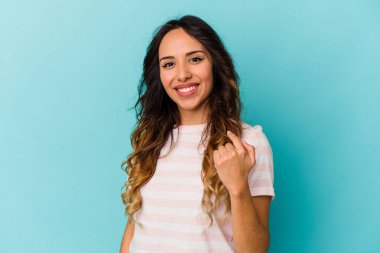 Mavi arka planda izole edilmiş genç Meksikalı kadın sanki seni davet ediyormuş gibi seni işaret ediyor..
